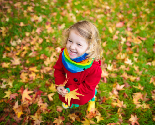Little girl playing with some leaves