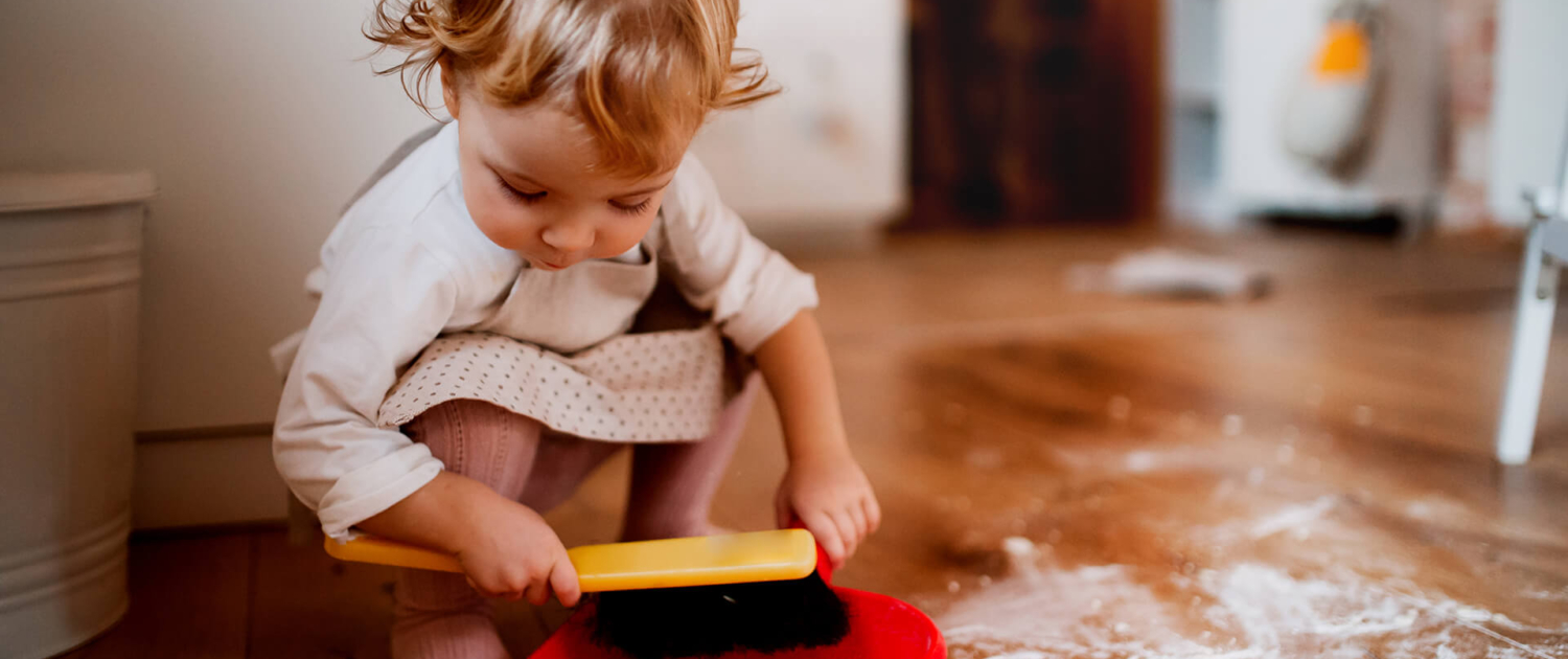 little girl with dustpan cleaning